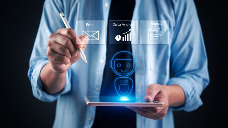 Man holding tablet with AI robot assistant hologram manage tasks including email, data analysis, and reporting. Concept artificial intelligence enhancing business productivity and office automation.