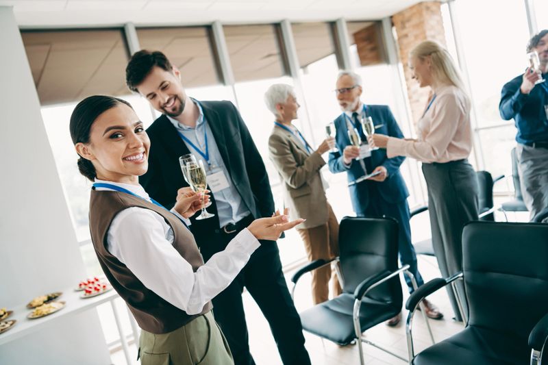 A group of professionals bonding over beverages at a work function, fostering teamwork, collaboration, and multicultural connections in a corporate setting.