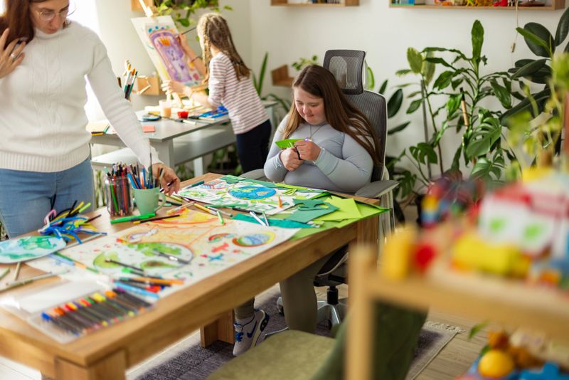 In this inclusive classroom, children of different races and abilities create a joint Earth Day poster under the teacher's guidance.