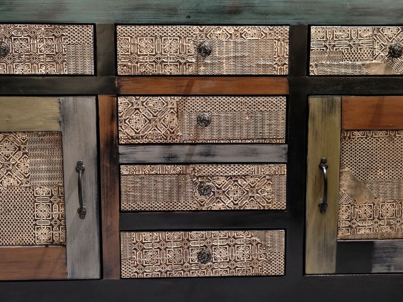 Rustic cabinet with textured drawers and metal handles showcasing handmade craftsmanship details, mixed