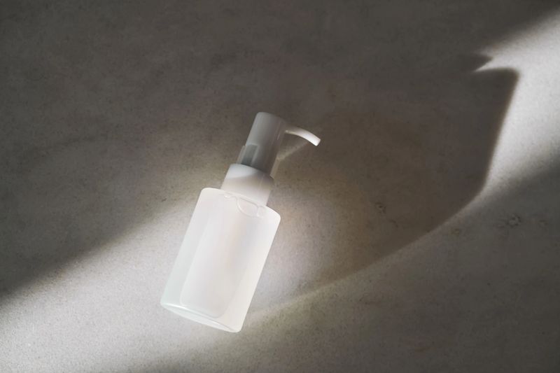 Minimalist cosmetic bottle on concrete surface with warm morning light