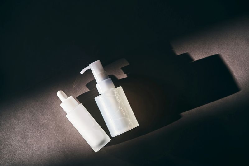 Skincare products on a dark background with dramatic light and shadows