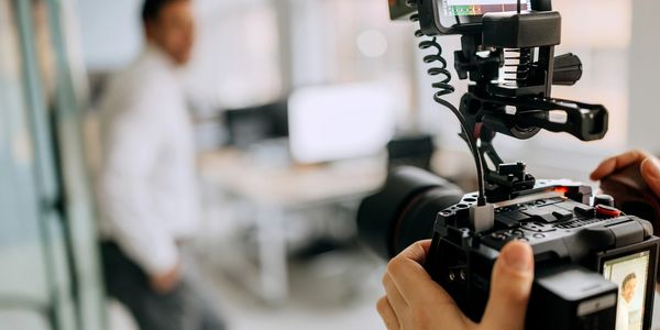Person filming another person in an office.