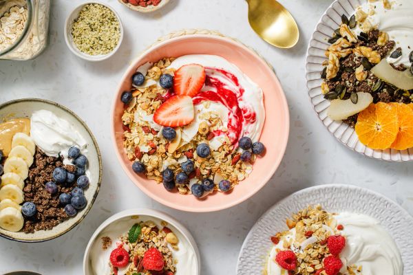 Bowls of yogurt with granola and fresh fruits.
