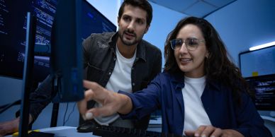 Two tech professionals collaborating at a computer.