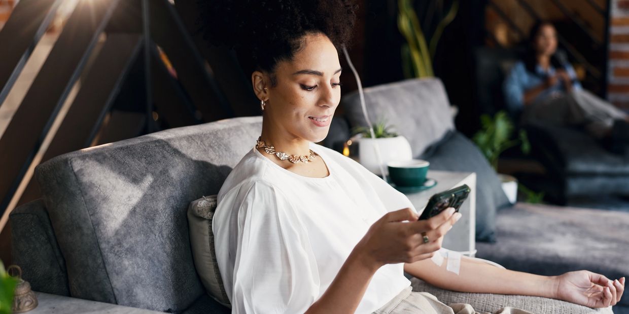 A woman relaxing on a couch using her phone.