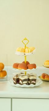 Rustic fall-inspired cake with greenery and doughnuts.