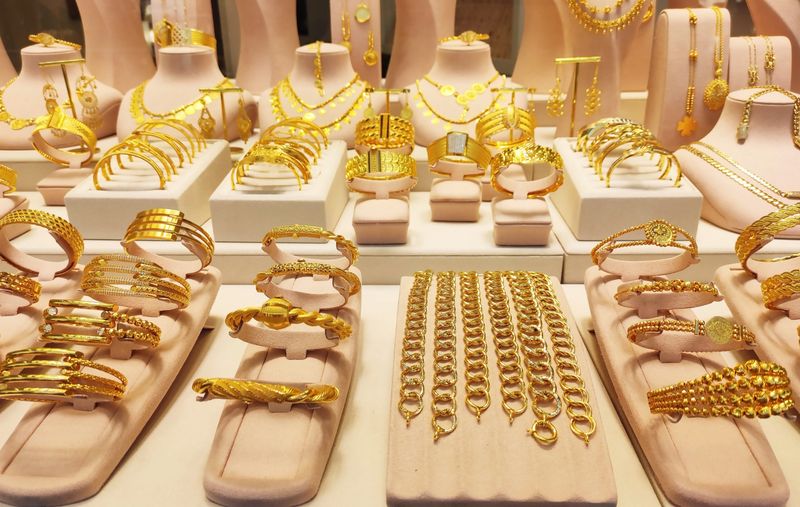 Luxury gold jewelry display in a boutique window. Elegant bracelets, necklaces and bangles