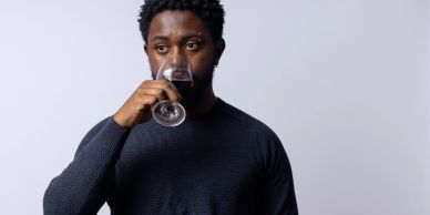 Man smelling the aroma of a drink in a glass.
