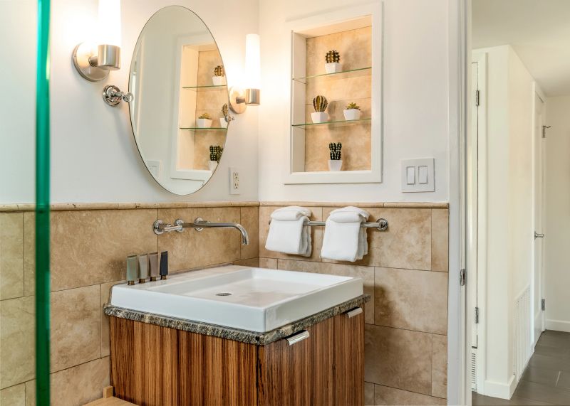 Modern bathroom with a floating wood cabinet, vanity sink, and round mirror