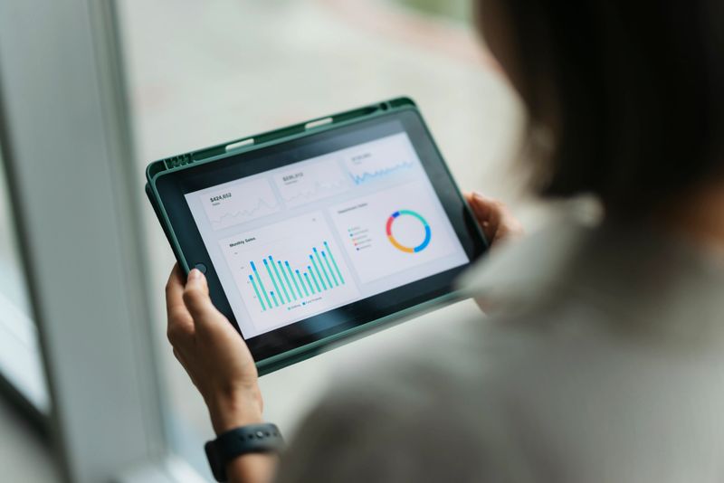 Person reviewing financial charts and graphs on a digital tablet for business analytics