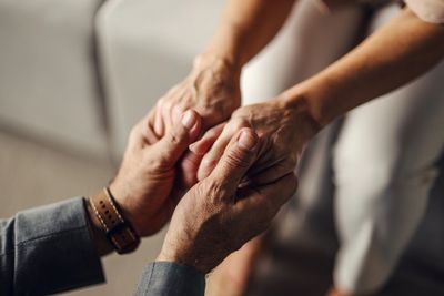 Two people holding hands in a comforting gesture.