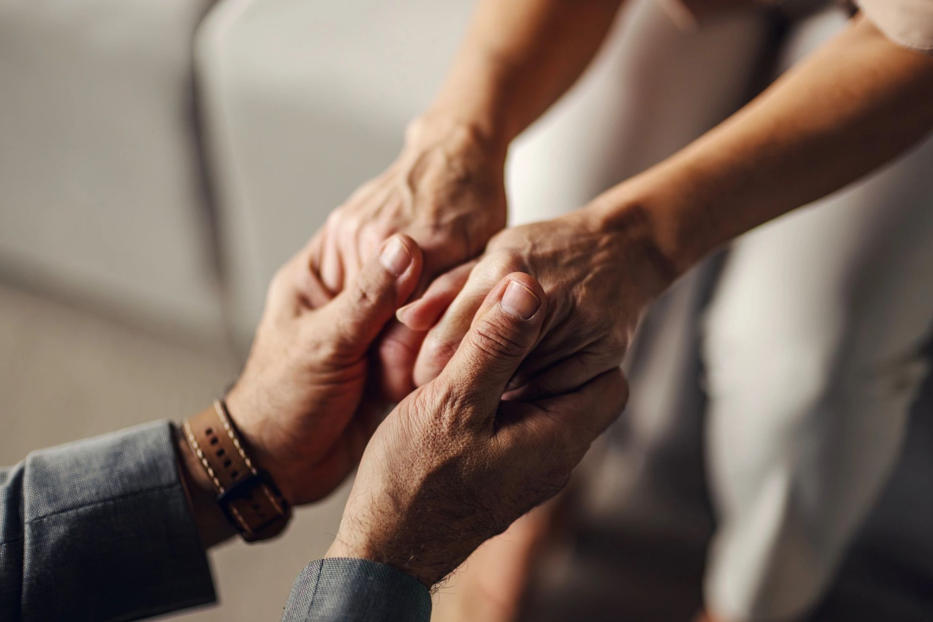 Two people holding hands in a comforting gesture.
