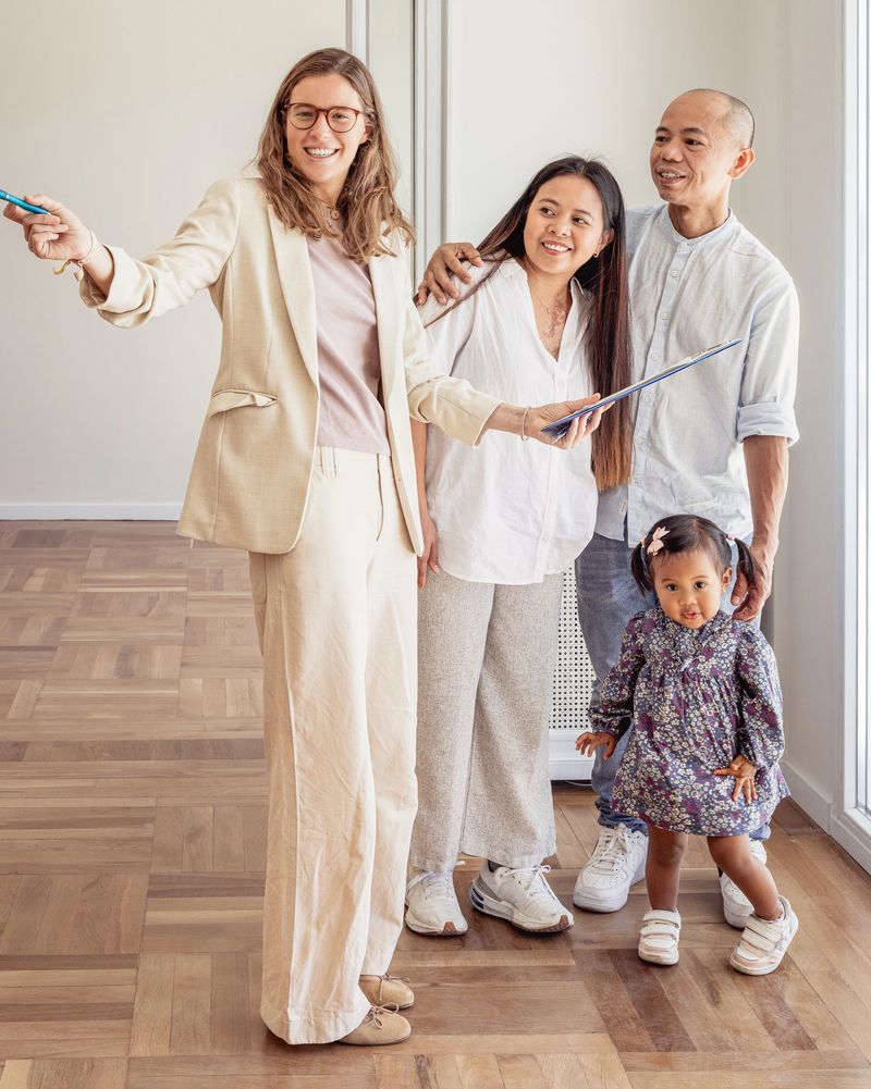 Real estate agent showing new home to happy family with baby daughter