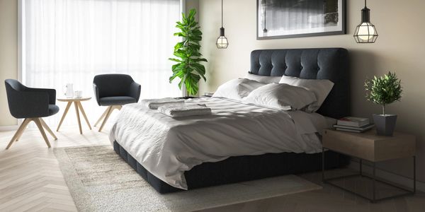 Modern bedroom with a neatly made bed and cozy seating area.