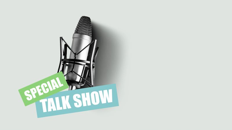 A microphone is set up in a recording studio for a podcast session with branding displayed.