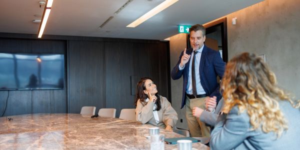 Business meeting with man speaking and two women listening.