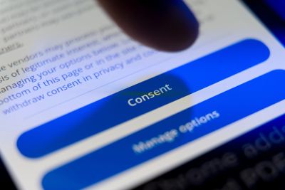 Finger about to tap a 'Consent' button on a digital screen.