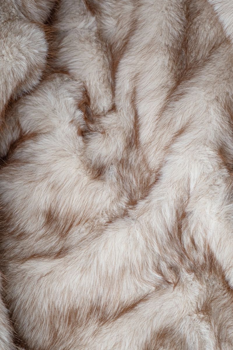 This plush textile creates a luxurious, inviting backdrop with its natural-looking, shaggy fibers.