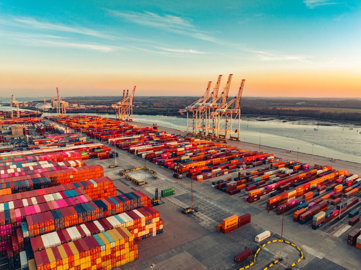 Aerial view of a busy container port at sunset.