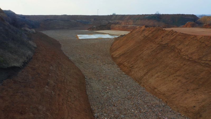 Open-pit quarry with slopes of sand and gravel, ready for extraction