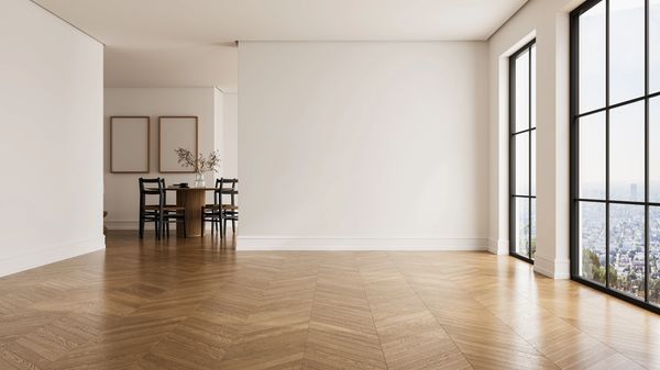 Empty room with wooden floor and large windows.