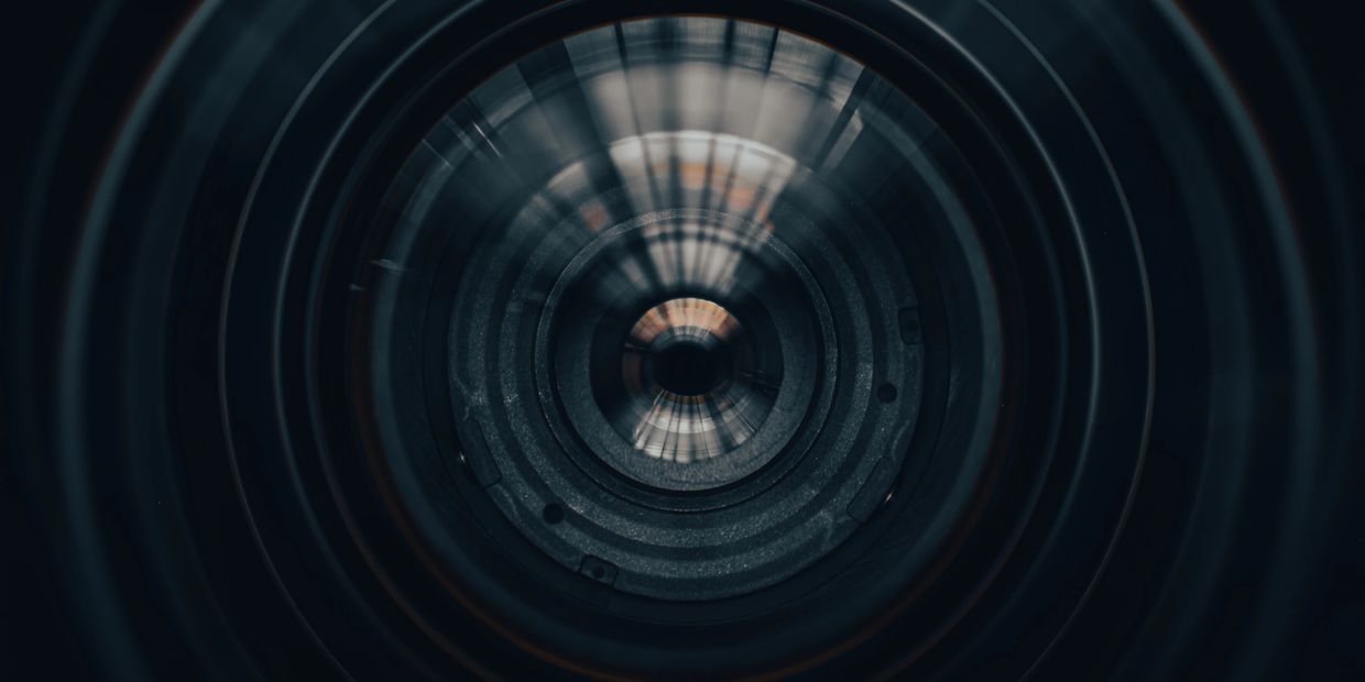 Close-up of a camera lens with light reflections.