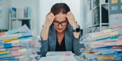 Stressed woman overwhelmed by paperwork.