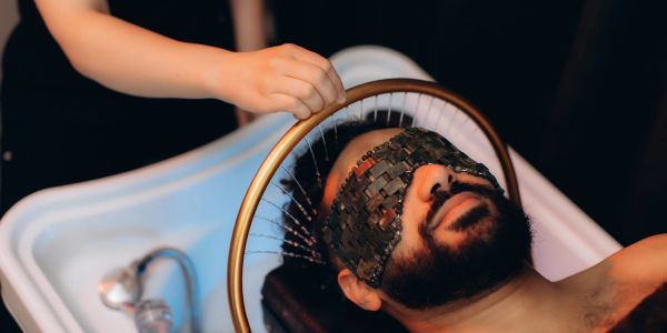 Man with blindfold receiving a unique treatment.
