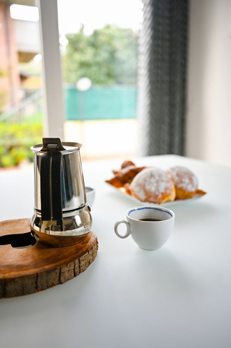Moka pot, coffee cup, and sweet pastries arranged for an inviting morning meal