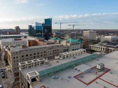 City skyline with a mix of modern and classical buildings under a blue sky.