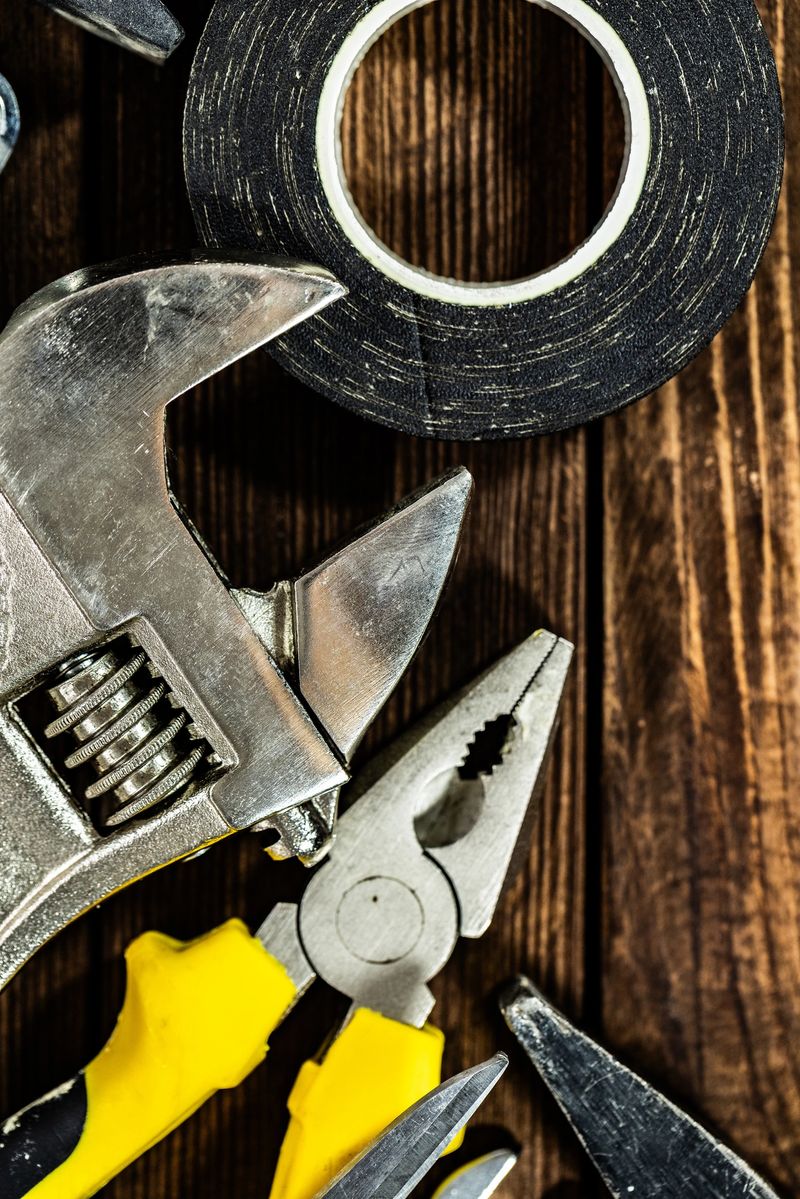 Professional building and household maintenance tools displayed on a rustic wooden background. Concept of home improvement, remodeling, craftsmanship, workshop organization, and construction industry work essentials.