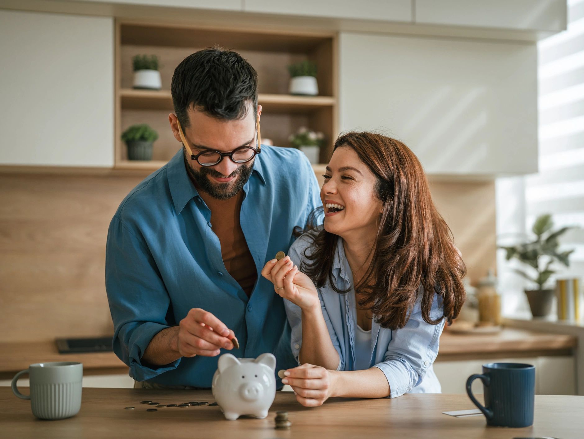 Happy couple saving money together with piggy bank.