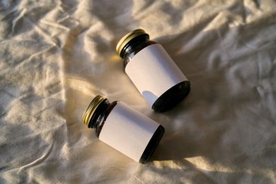 Two small dark glass bottles with blank white labels.