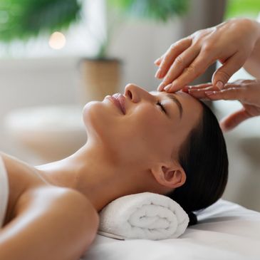 Woman enjoying a relaxing facial massage in a spa.