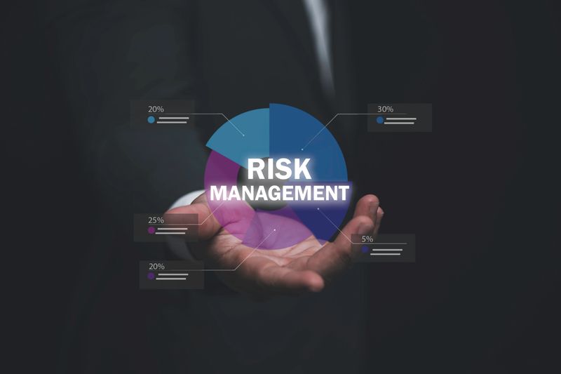 Businessman hand holding virtual pie chart with Risk Management text. Professional financial planning, corporate security, insurance, and data analysis for strategic business growth and stability.