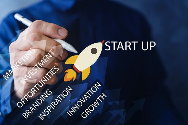 Businessman highlights key factors for startup success with a rocket icon.