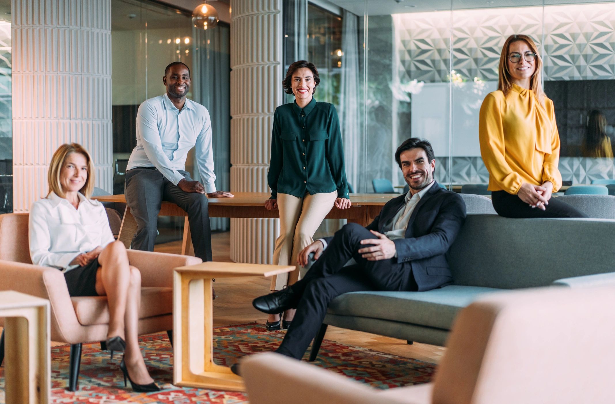 Groupe de collègues souriants dans un bureau moderne.