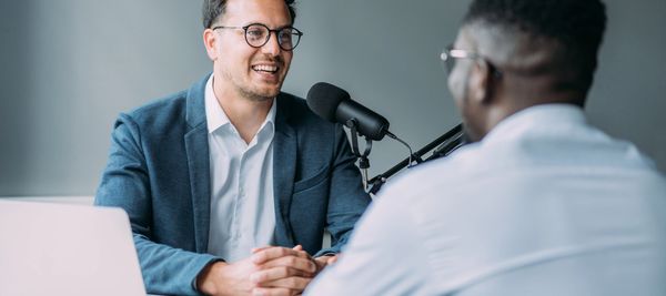 Two men recording a podcast in a professional setup.