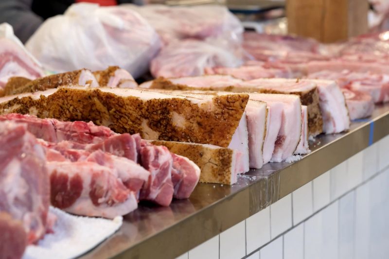 Fresh cuts of meats lined up attractively at a vibrant market stall. Kyiv, Ukraine. December 12, 2025.