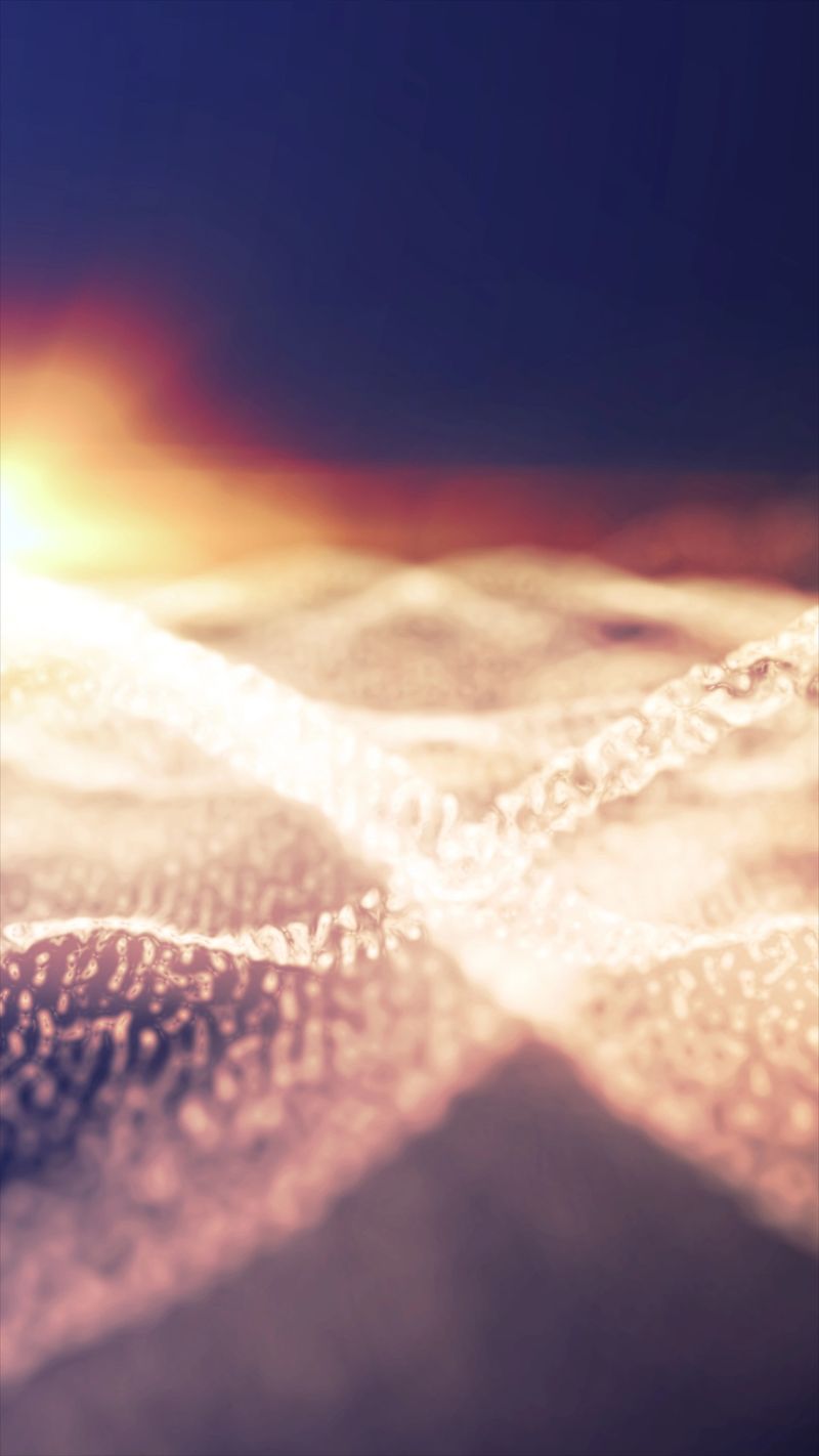 Soft glowing abstract landscape with warm light illuminating fluid wave-like patterns at sunrise.