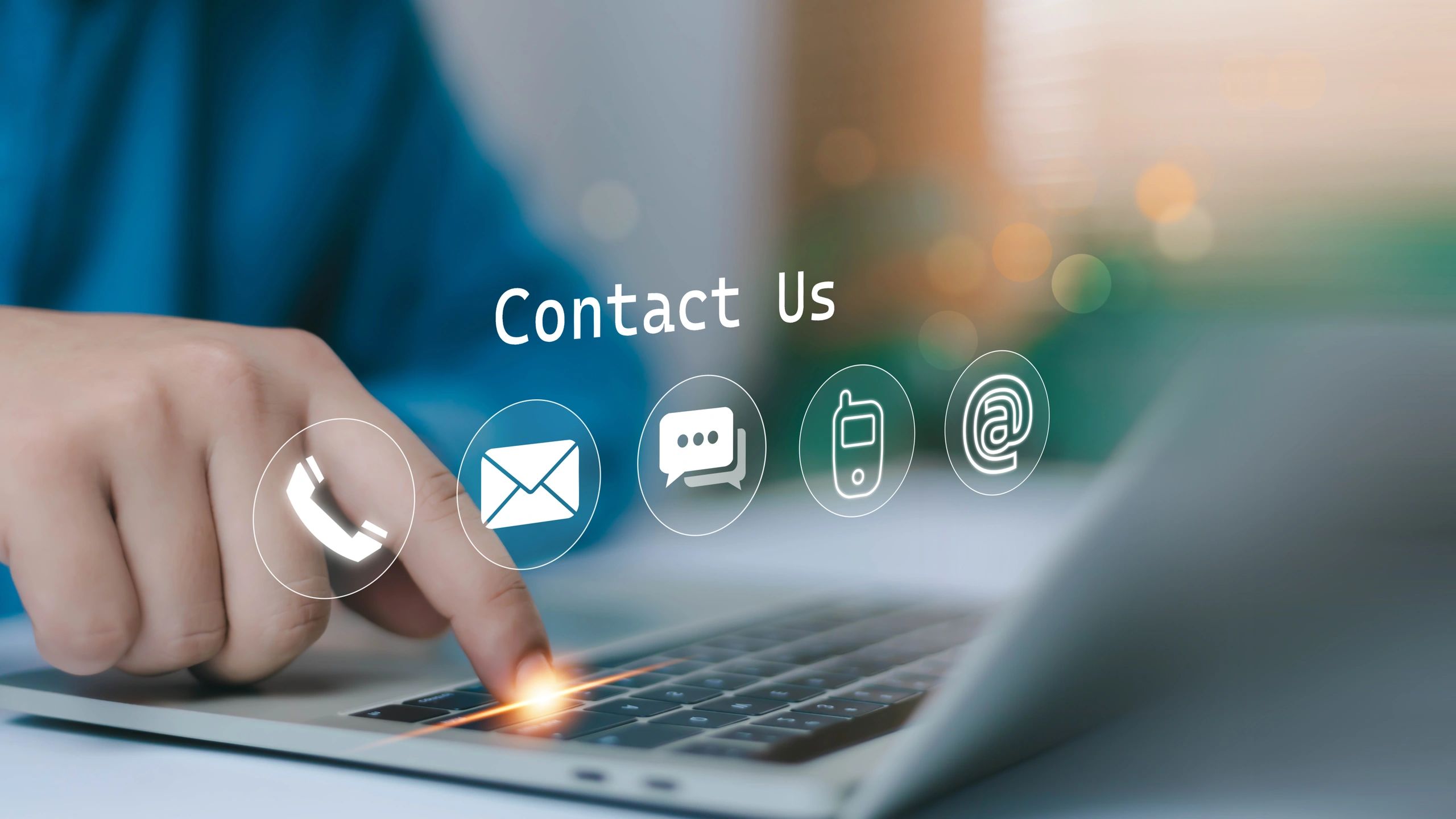 Person pressing laptop keyboard with contact icons and 'Contact Us' text overlay.