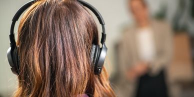 Person wearing headphones listening to someone.