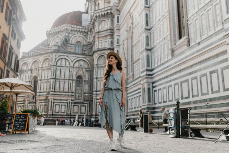 Young woman strolling through the historic streets of Florence, Italy. Renaissance architecture, cobblestone streets, and charming urban scenery create an authentic European travel experience. Concept of tourism, city exploration, and lifestyle photography.