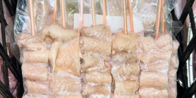 Frozen skewers of meat wrapped in plastic.