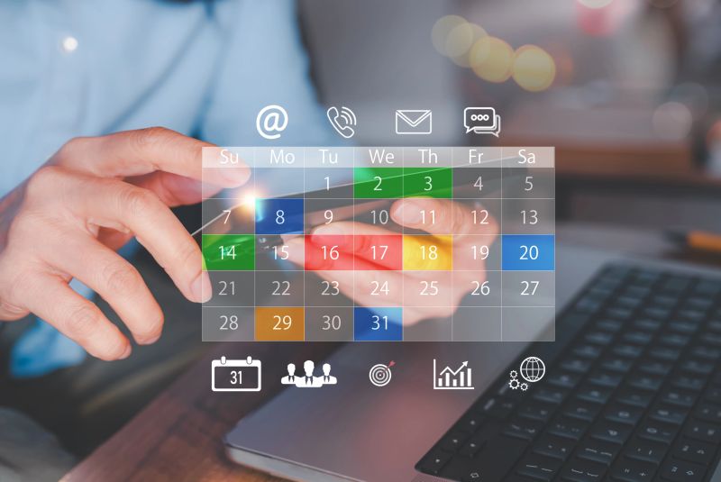Business planning concept with digital calendar interface overlay on smartphone and laptop. Online meeting, email marketing, newsletter scheduling and organization management in modern workspace