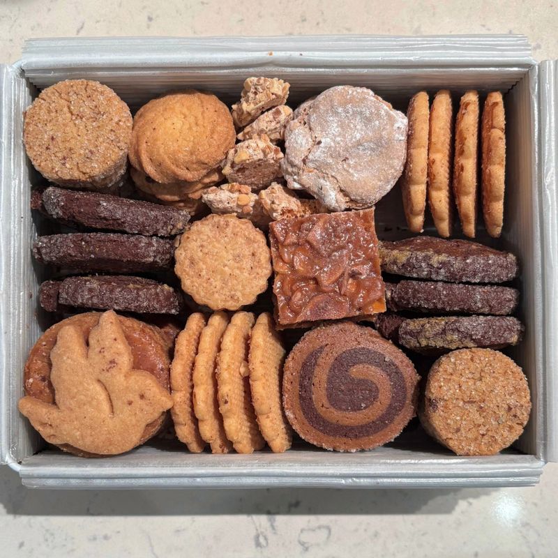 Assorted cookies neatly arranged in tins, showcasing different shapes, textures, and colors. Cozy, nostalgic, and inviting, perfect for festive treats, homemade gifts, and warm kitchen moments.