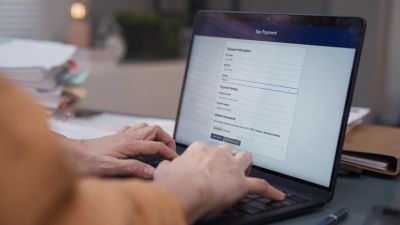 Person filling out an online form on a laptop.