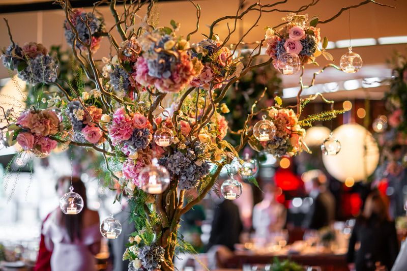 Floral Centerpiece with Hanging Glass Candles at Event