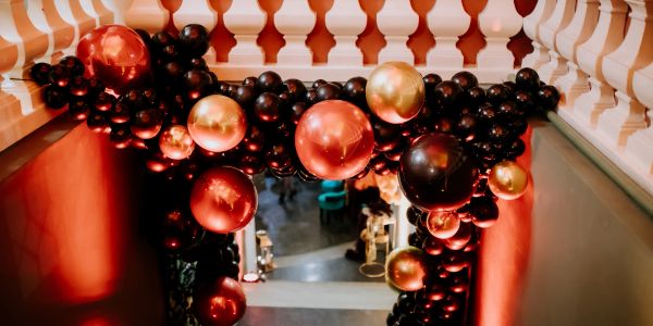 Black, red, and gold balloon decoration on staircase.